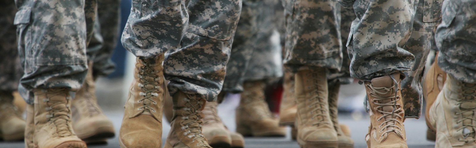 Photo of people in camoflague pants and tan combat boots, from the knee down