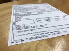 A picture of a DD Form 214 form on a wooden table.