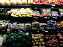 A shelf full of vegetables in a grocery store.