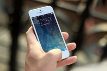 A person holds a white iPhone