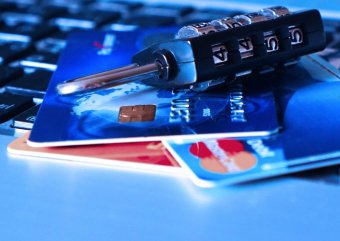 A photo of several credit and debit cards and a padlock on a table