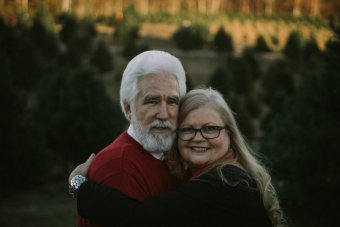 Photo credit: Seth Hays. An older white couple stands, hugging and looking at the camera.