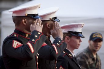 A photo of two men and a woman in U.S. Marine Corps dress uniform, saluting. 