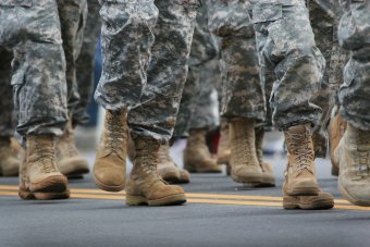 Photo of people in camoflague pants and tan combat boots, from the knee down